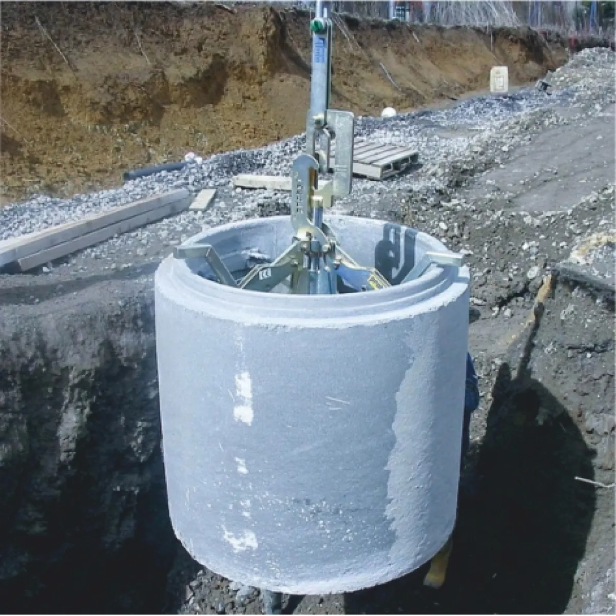 Beton kútgyűrű beemelése munkaárokba FE 1067 emelővel | Texem Előregyártott nehéz beton kútgyűrű biztonságos leeresztése és beemelése a földmunkagödörbe az FE 1067 automata megfogórendszerrel | Texem